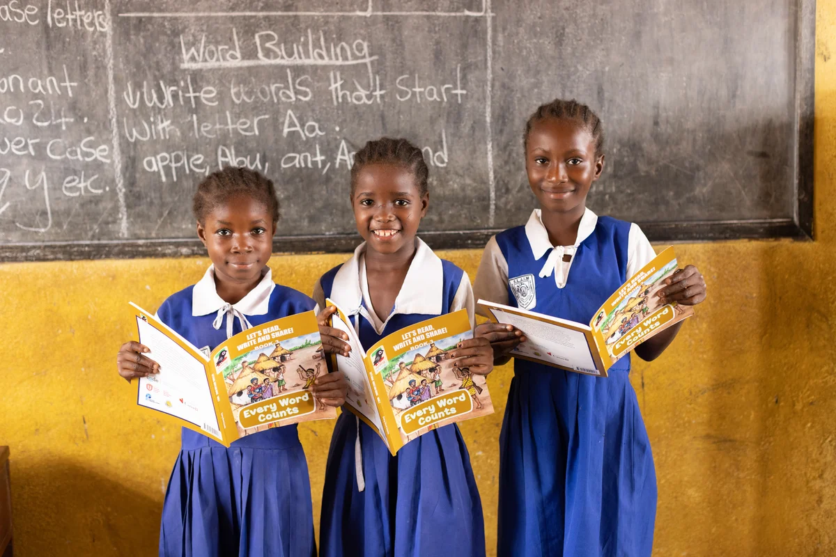 Three girls reading the same book together